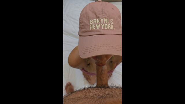 Asian milf in a pink cap is giving me a blowjob.