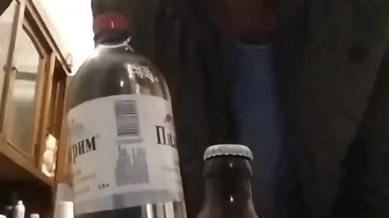 opening a bottle of beer with a bottle of mineral water